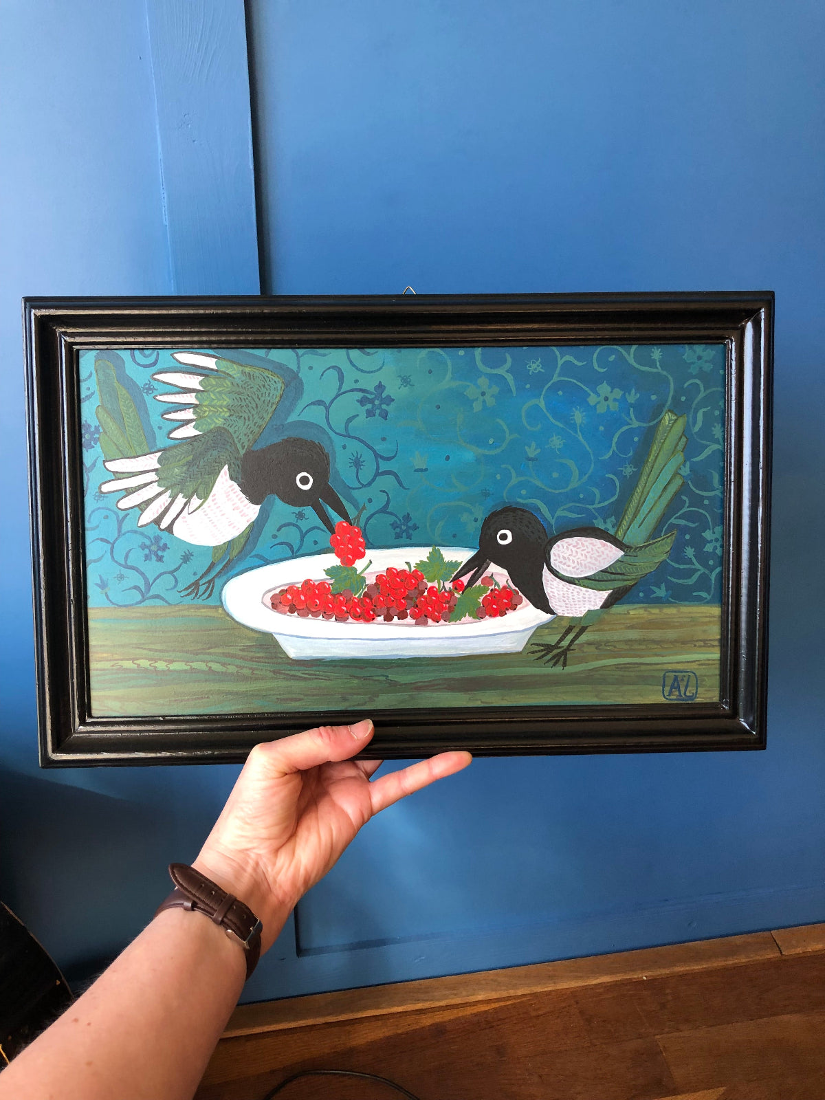 Stilleven schilderij van twee eksters die samen een wit ord met rode bessen leeg snoepen. Dit keuken stilleven in blauwe kleuren is grappig en stijlvol tegelijk. Dit handgeschilderde en handgemaakte keuken stilleven, past mooi in een kleurrijk interieur.