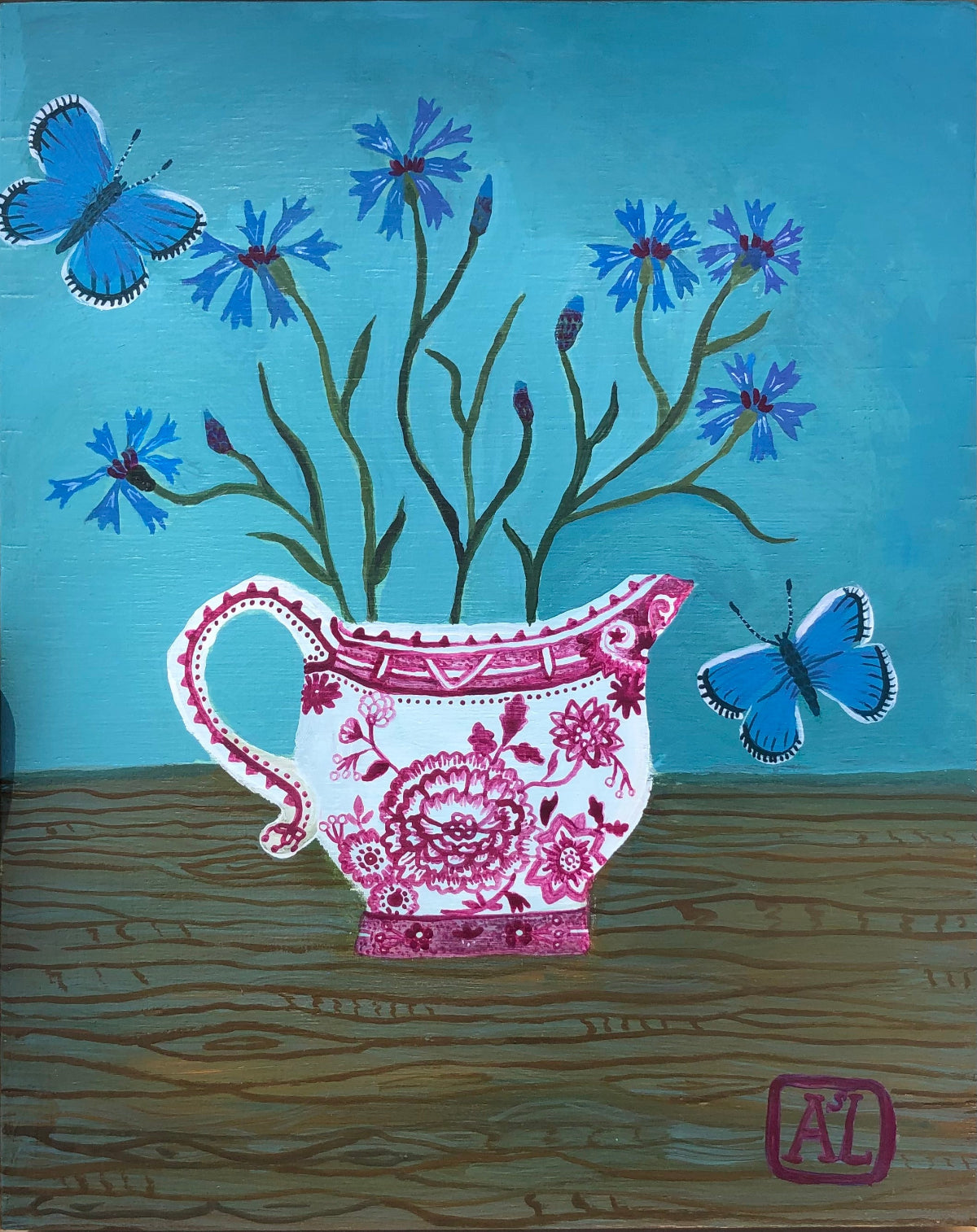 kleurrijk handgeschilderd korenbloem stilleven in blauwe tinten. De korenbloempjes staat in een burgenland  theekopje van villeroy en boch. Op dit handgemaakte schilderij staan ook twee blauwe vlindertjes. Dat zijn icarus blauwtjes.