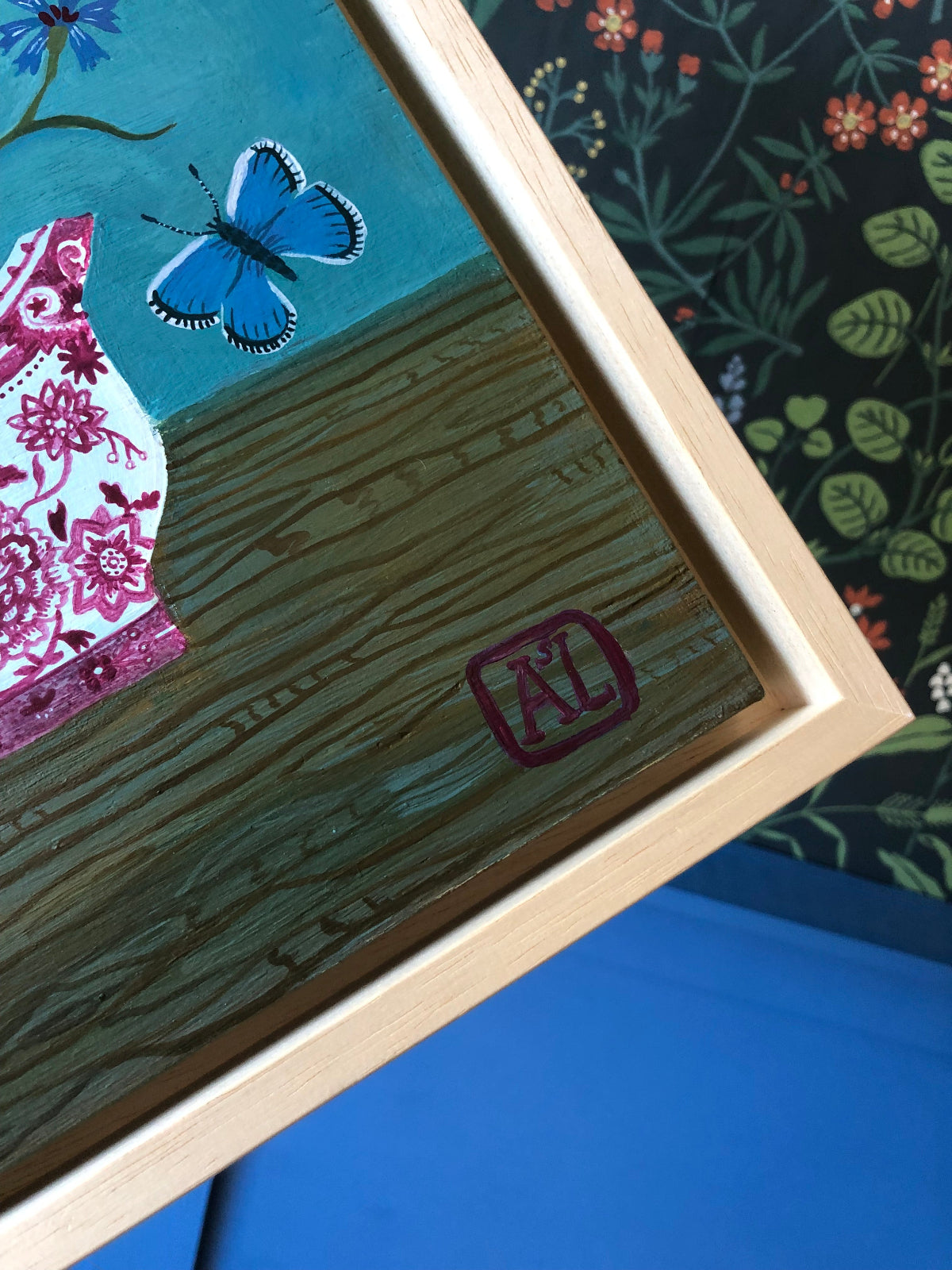 kleurrijk handgeschilderd korenbloem stilleven in blauwe tinten. De korenbloempjes staat in een burgenland  theekopje van villeroy en boch. Op dit handgemaakte schilderij staan ook twee blauwe vlindertjes. Dat zijn icarus blauwtjes.