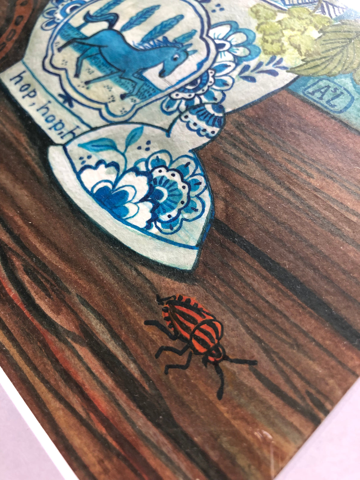 wilde bloemen stilleven schilderij in natuurlijke tinten als blauw, bruin en groen. Dit boeket staat in een Delfts Blauwe Vaas met een paard in galop. Op de tafel naast de blauw witte vaas ligt een hoefijzer. Dit bloem stilleven met hopplanten heeft een hoefijzer en twee vlindertjes. De vlinders zijn oranje tipjes.